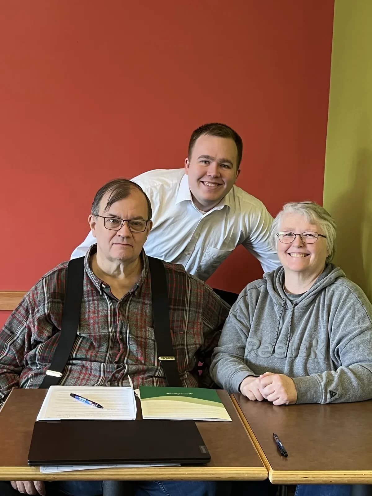 Hunter Klaassen reviewing a final expense insurance policy with a senior couple at his Jackson, MI office