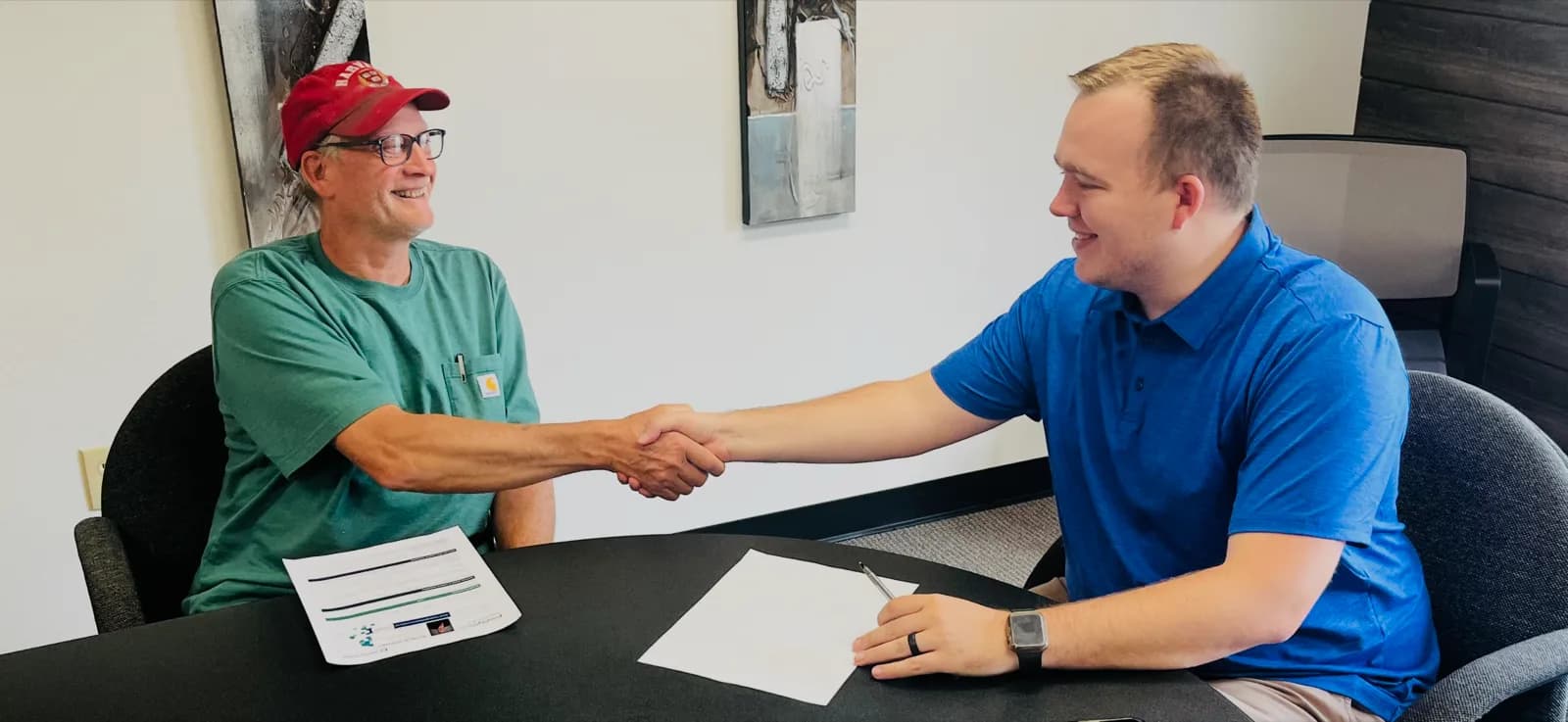 Hunter Klaassen shaking hands with a neighbor after helping them with their insurance in Jackson, MI